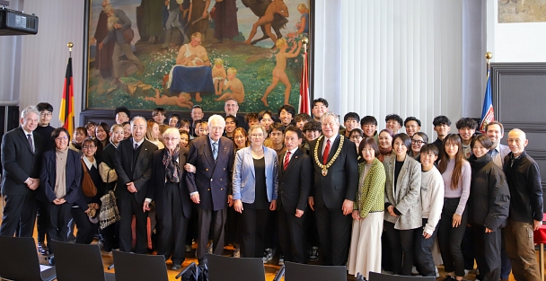 Eine Gruppe von japanischen Universitätsangehörigen und deutschen Gastgebern bei einem Gruppenfoto im Rathaussaal. © Lena-Johanna Schmidt, Stadt Marburg